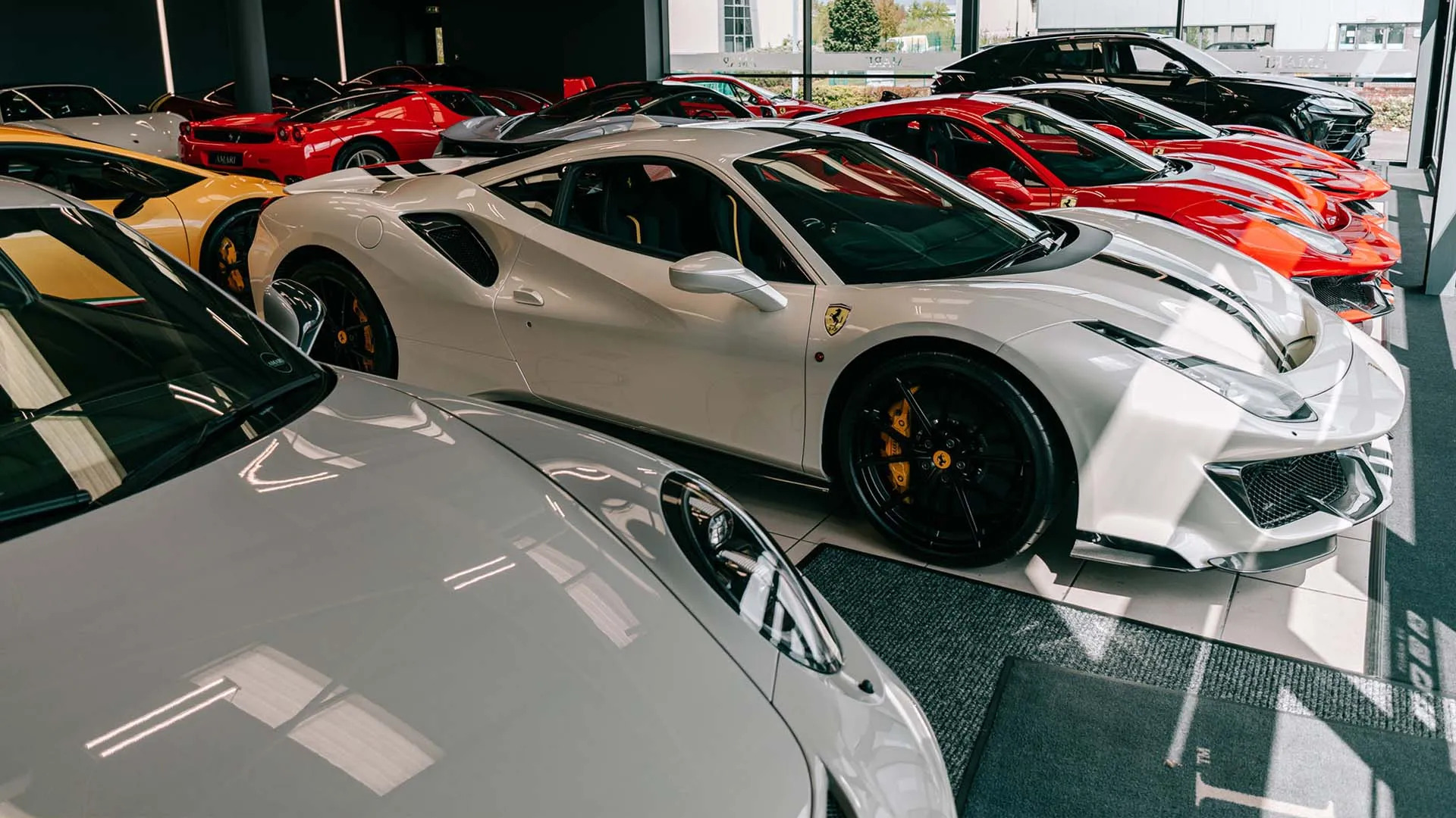 Premium luxury car showroom with Ferrari and high-end sports cars